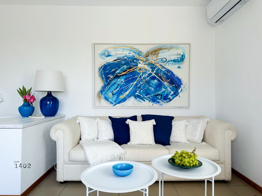 Living area with sofa and blue painting on the wall