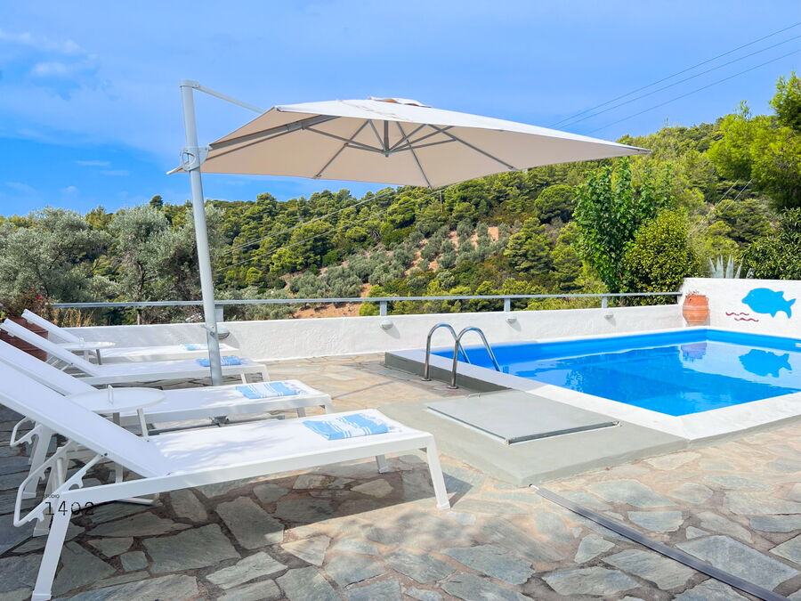 Sun loungers by the pool under the parasol