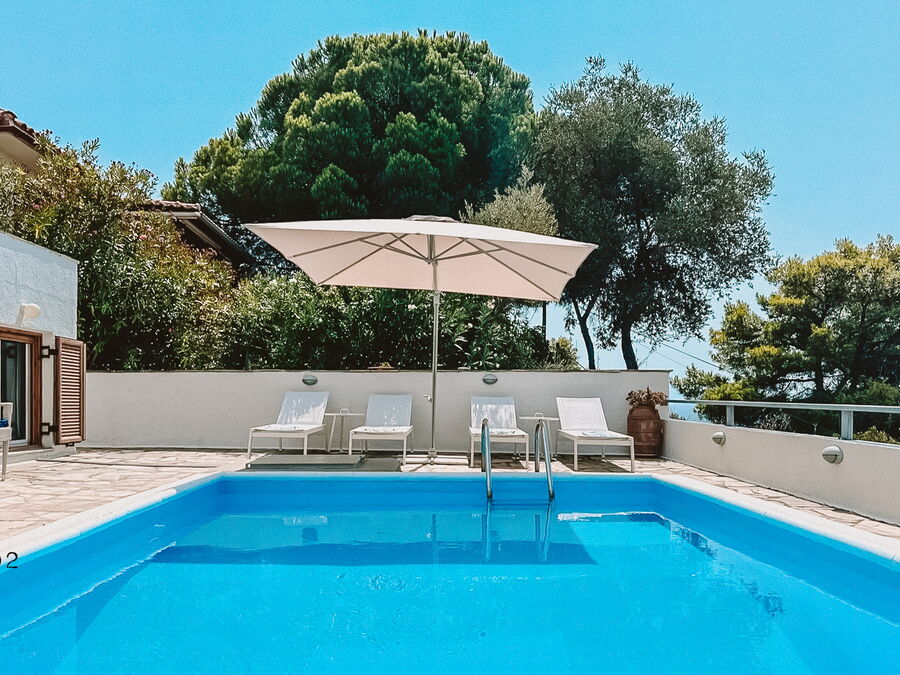 Pool with sun loungers and parasol